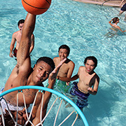 students playing basketball in pool