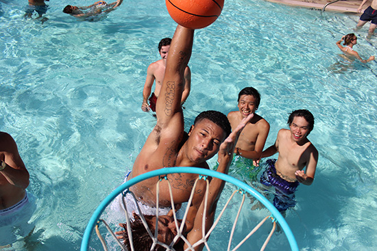 students playing basketball in pool