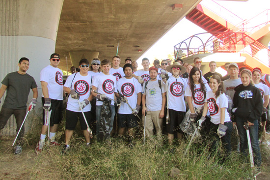 students pose at the river clean-up site