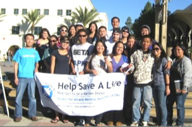 Greeks holding a banner that reads Help Save a Life