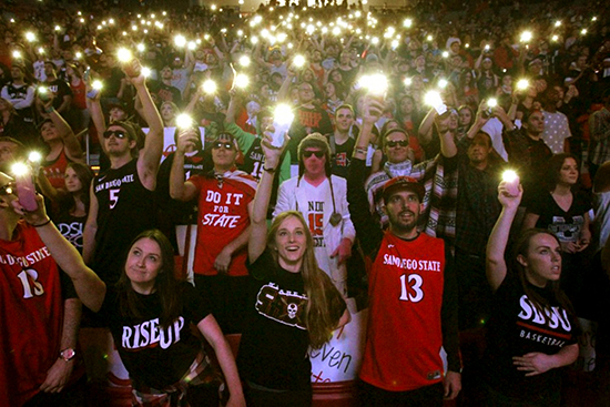 crowd of students at the show holding up their cell phone lights at night