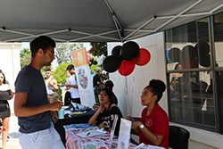 students at booth inquiring about volunteering