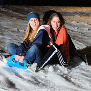 students sledding in the snow